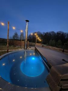 una bañera de hidromasaje en un patio por la noche en Glamping Kaszuby, en Pomysk Wielki