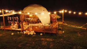a tent with lights in a field at night at Glamping Kaszuby in Pomysk Wielki