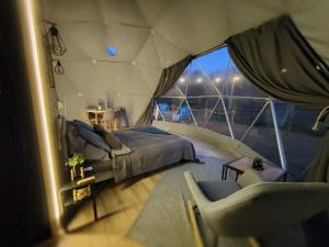 Pomysk WielkiGlamping Kaszuby的帐篷内一间卧室,配有一张床和椅子