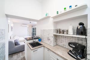 eine kleine Küche mit Spüle und Sofa in der Unterkunft Studio Apartment Lapad in Dubrovnik