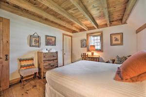 a bedroom with a large bed and a chair at Family-Friendly Farmhouse - Near Lake and Ski Areas! in Harbor Springs