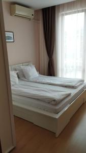 een bed in een kamer met een raam bij Private Apartment 49 in Prestige Fort Beach Hotel in Sveti Vlas