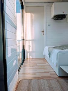 um pequeno quarto com uma cama e uma janela em Schwimmendes Haus Johanne auf dem Wasser inkl Boot in Blankaholm em Blankaholm
