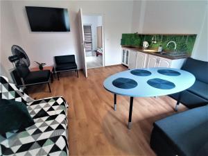 a living room with a table and a kitchen at Chmarnik in Polańczyk