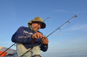 a man in a kayak holding two fishing rods at Mamaqocha in Canoas de Punta Sal