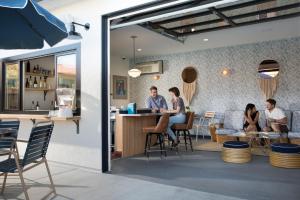 a group of people sitting at a bar in a restaurant at Sandman Hotel in Santa Rosa