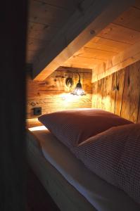 a bed in a room with a wooden wall at Chalet Bergliebe in Brilon