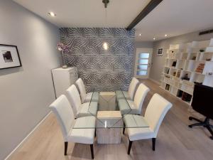 a dining room with a glass table and white chairs at Moderno y Centrico Piso en Cartagena in Cartagena