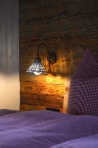 een bed met een licht aan een houten muur bij Chalet Bergliebe in Brilon