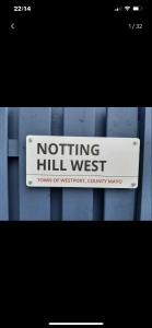 a sign that reads nothing hill west on a fence at Notting Hill West in the heart of Westport Town in Westport