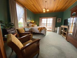 a bedroom with a bed and chairs in a room at Hanlon Guest House in Stanley