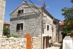 uma antiga casa de pedra com uma parede de pedra em Vacation home Ania em Prvić Luka