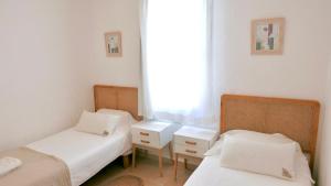 two twin beds in a room with a window at Es Cucó in Cala Galdana