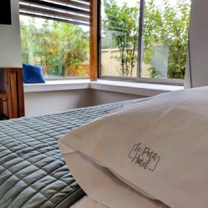a bed with a comforter with the words he right field on it at Hotel Le Petit in Concepción