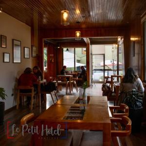 ein Restaurant mit Leuten, die an Tischen in einem Zimmer sitzen in der Unterkunft Hotel Le Petit in Concepción