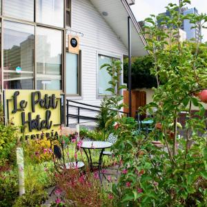 a garden in front of a house with a table and flowers at Hotel Le Petit in Concepción