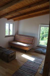 a living room with a couch and two windows at Badacsony Vendégház in Badacsonytördemic