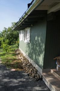 a green house with a pile of rocks next to a building at Badacsony Vendégház in Badacsonytördemic