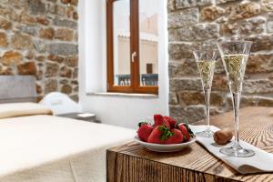 einen Tisch mit einer Schale Erdbeeren und zwei Gläsern Champagner in der Unterkunft Il Busciolotto in Santa Teresa Gallura
