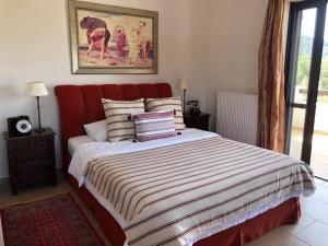 un letto con testiera rossa in una camera da letto di Elaion mini suites a Nauplia