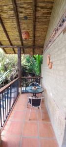 a patio with a table and chairs on a balcony at Hacienda Mawaka in Ráquira