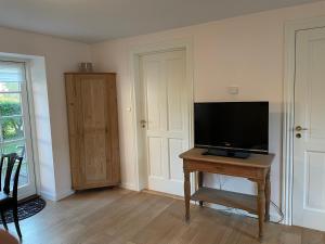 維比的住宿－Vita og Pouls Gård - Guesthouse，客厅配有木桌上的电视