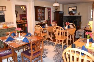 a dining room with tables and chairs and a fireplace at Benjamin Prescott Inn in Jaffrey