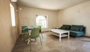 ein Wohnzimmer mit einem Sofa, einem Tisch und Stühlen in der Unterkunft Résidences Canta Furmigula in Patrimonio