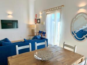 a living room with a table and a blue couch at Es Cucó in Cala Galdana