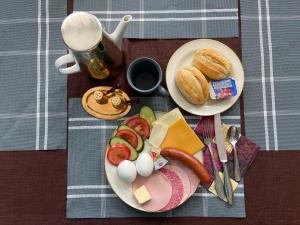 a table with two plates of food and a cup of coffee at Gemütliches Apartment mit Kamin und Wohnküche in Herzberg am Harz