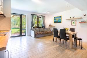 salon ze stołem, krzesłami i kanapą w obiekcie Apartamenty - Dom Smołdziński Las w Smołdzińskim Lesie