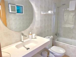 a bathroom with a sink and a toilet and a mirror at Es Cucó in Cala Galdana