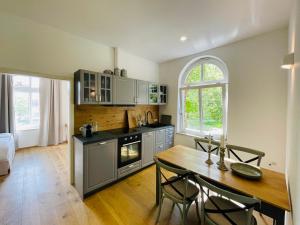 a kitchen with a wooden table and a dining room at Kaiserliche Post Suites Bevensen-Ferienwohnung in Bad Bevensen