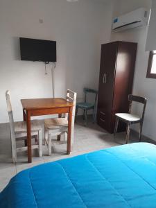 een kamer met een bureau en een tafel en stoelen bij MONOambienteporDIA in Bahía Blanca