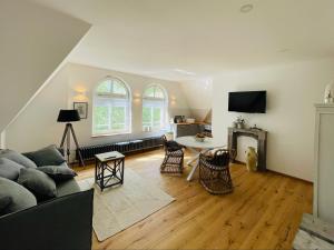 a living room with a couch and a fireplace at Kaiserliche Post Suites Bevensen-Ferienwohnung in Bad Bevensen