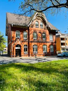 ein großes Backsteingebäude mit einem davor geparkt in der Unterkunft Kaiserliche Post Suites Bevensen-Ferienwohnung in Bad Bevensen