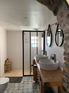 La salle de bains est pourvue de 2 lavabos et de 2 miroirs. dans l'établissement BELLE maison avec JARDIN  à Arradon, à Arradon