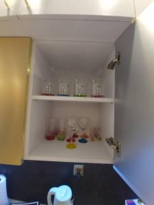 a shelf with glasses on it in a laboratory at Apartament Rainbow in Białystok