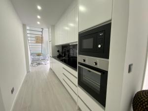 a kitchen with a microwave oven and a stove at Luxury Loft Apartment in Ribeira Grande
