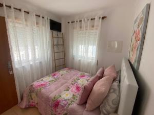 - une chambre avec un lit doté de draps roses et de fenêtres dans l'établissement Faneca Beach Room - Faneca Apartamentos, à Nazaré