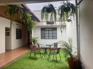a patio with a table and chairs and plants at El Extranjero Hostal in Antigua Guatemala