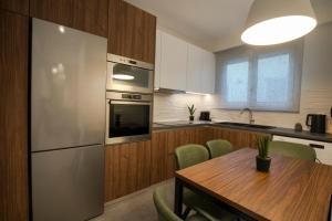 ロードス・タウンにあるUnique Central Lee Pham Apartmentのキッチン(木製テーブル、ステンレス製の冷蔵庫付)