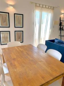 uma sala de jantar com uma mesa de madeira e cadeiras brancas em Es Cucó em Cala Galdana