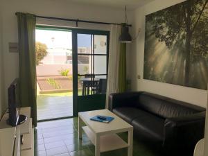 a living room with a leather couch and a table at Casa Luna in Puerto del Carmen