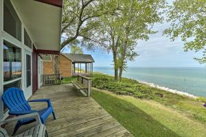 un portico di una casa con due sedie blu sopra di Lakefront Cottage Near Wineries and State Parks! a Mears
