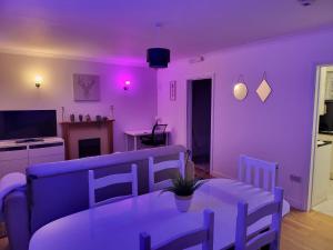 a purple living room with a table and a couch at 2Bed Bungalow House, Speedwell, Bristol, UK, sleeps up to 6 guests in Bristol