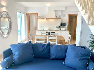a blue couch in a living room with a kitchen at Es Cucó in Cala Galdana