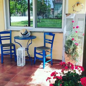 a porch with two chairs and a table and a window at Amaryllis sweet home in Pyrgos