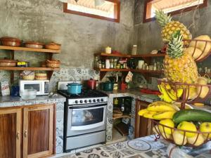 a kitchen with a stove and a pineapple on the counter at Cabañas Mannan in Tanchachín