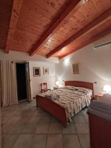 a bedroom with a large bed and a wooden ceiling at Playa Bonita Relax House in Scilla